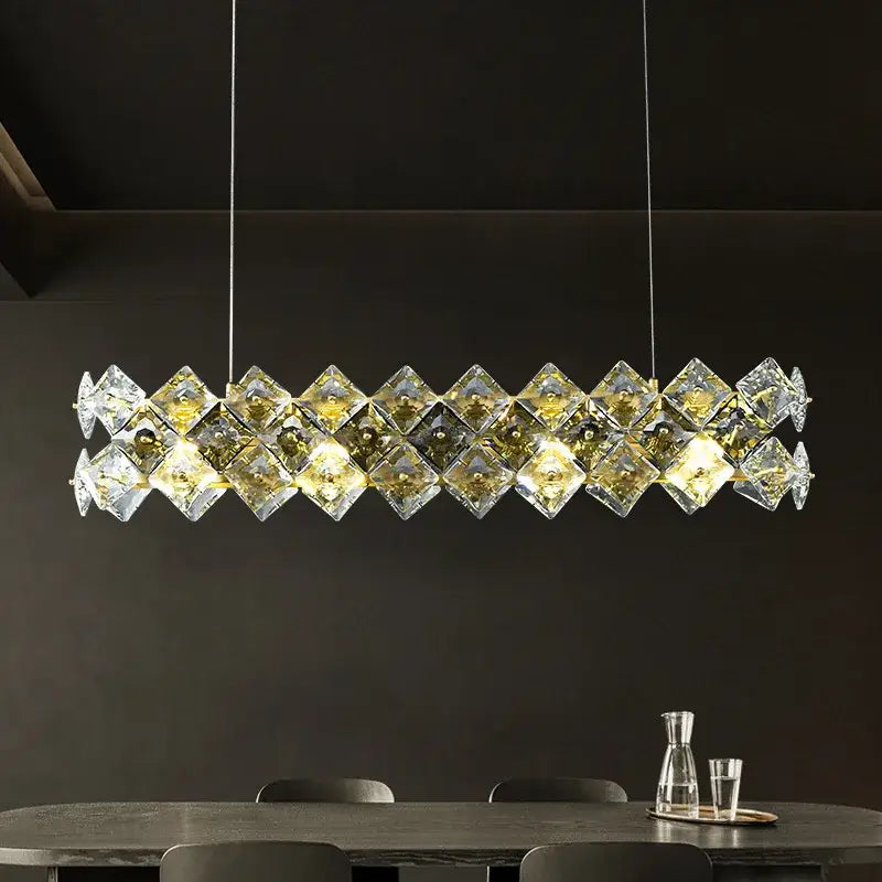 A modern gold decorbites crystal round chandelier with clear faceted glass cubes and warm golden lighting for dining rooms