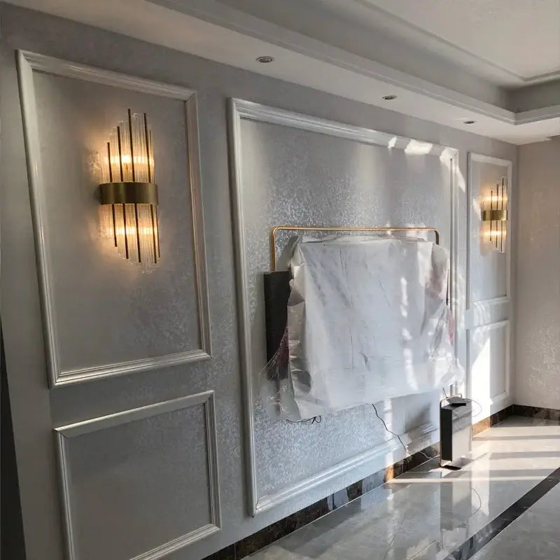 Modern gold decorbites crystal wall lamp with gold-toned vertical rod design and warm glowing light for luxury decor