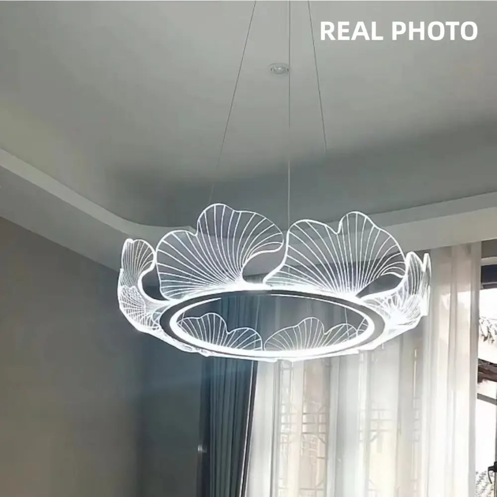 A modern gold decorbites ginkgo acrylic led pendant with glowing white light and intricate ginkgo leaf design for dining room