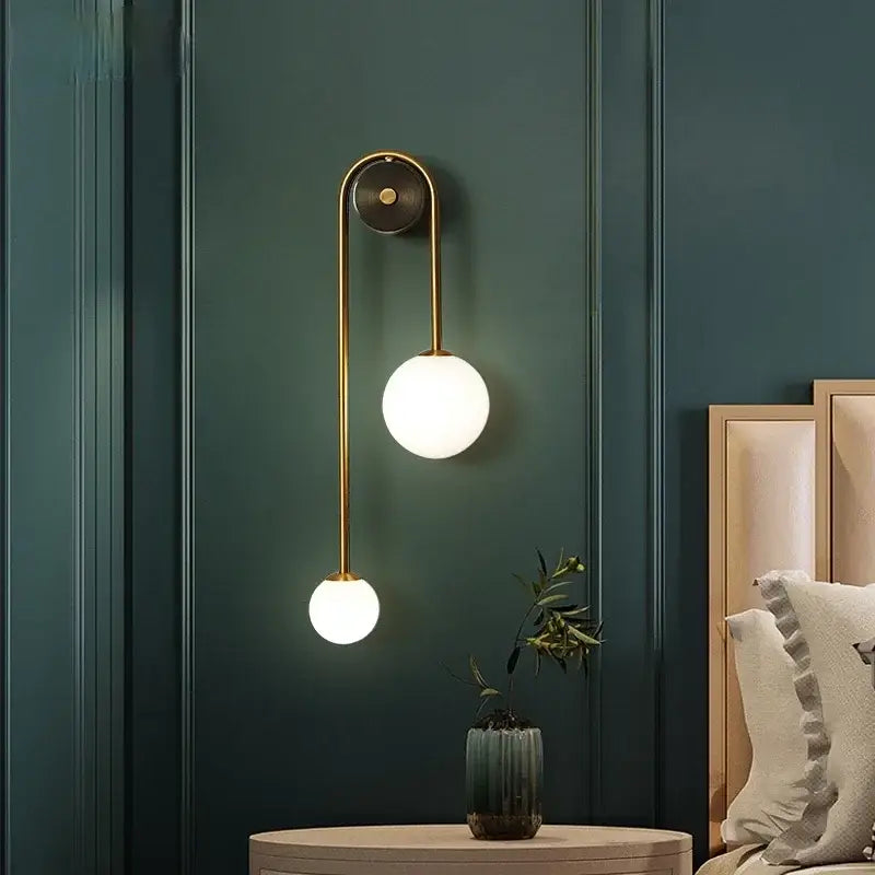Modern gold decorbites glass ball led wall lamp features a gold-toned wall sconce with two frosted glass shades