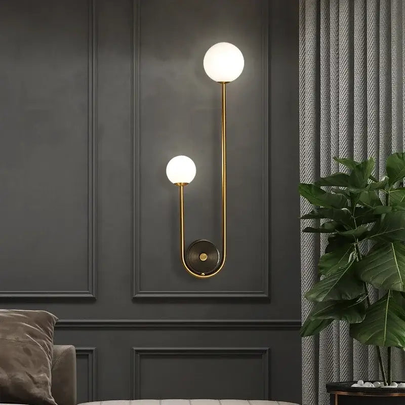 Modern gold decorbites glass ball led wall lamp with two spherical frosted globes and curved metallic arm bedroom sconce