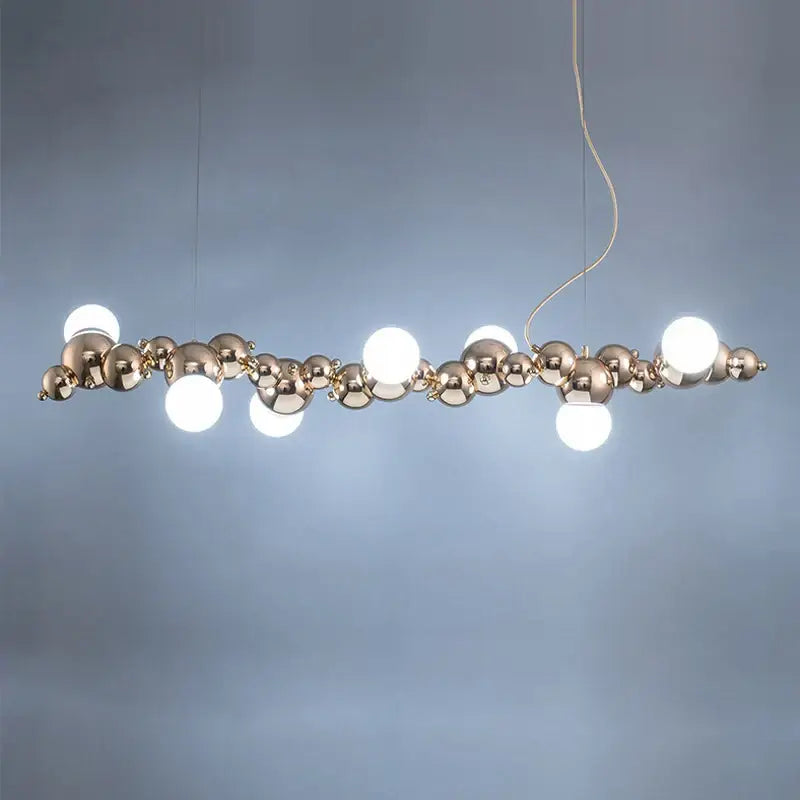 Modern gold designer molecule chandelier featuring polished gold-toned spheres and integrated white led lights for dining room decor