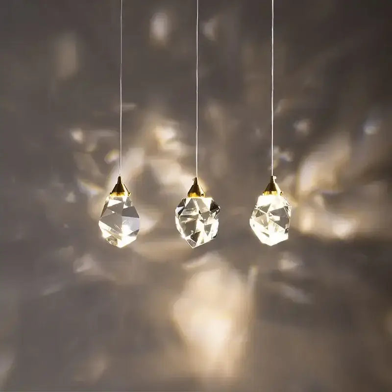 Three gold-toned crystal ball chandelier pendant lights with faceted diamond crystal ball glass for living room use