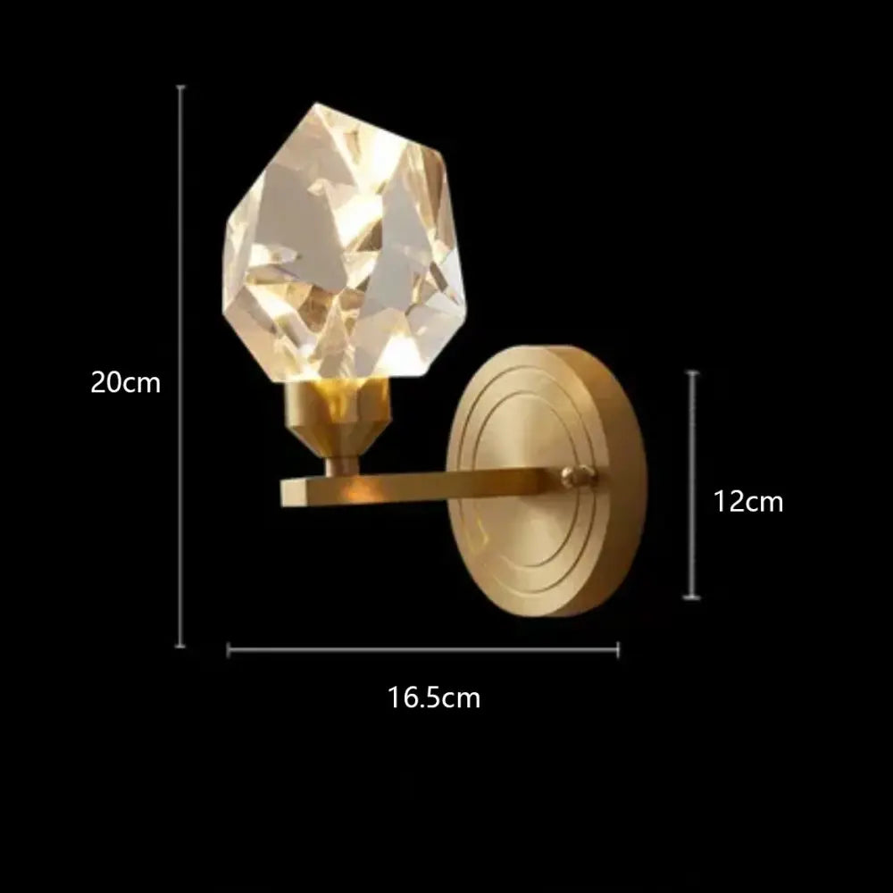 A faceted crystal sconce with a gold-toned diamond crystal brass led pendant light arm for modern dining rooms