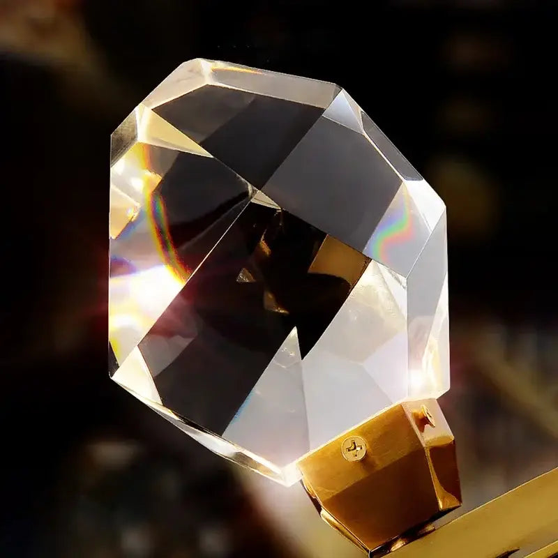 A faceted crystal door knob with a gold-toned base complements the modern gold diamond crystal chandelier for staircase
