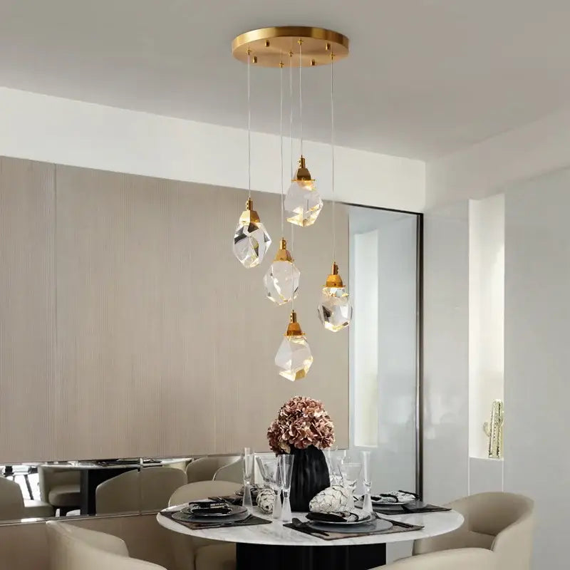 A modern gold diamond crystal chandelier with five faceted crystal pendants for living room lighting