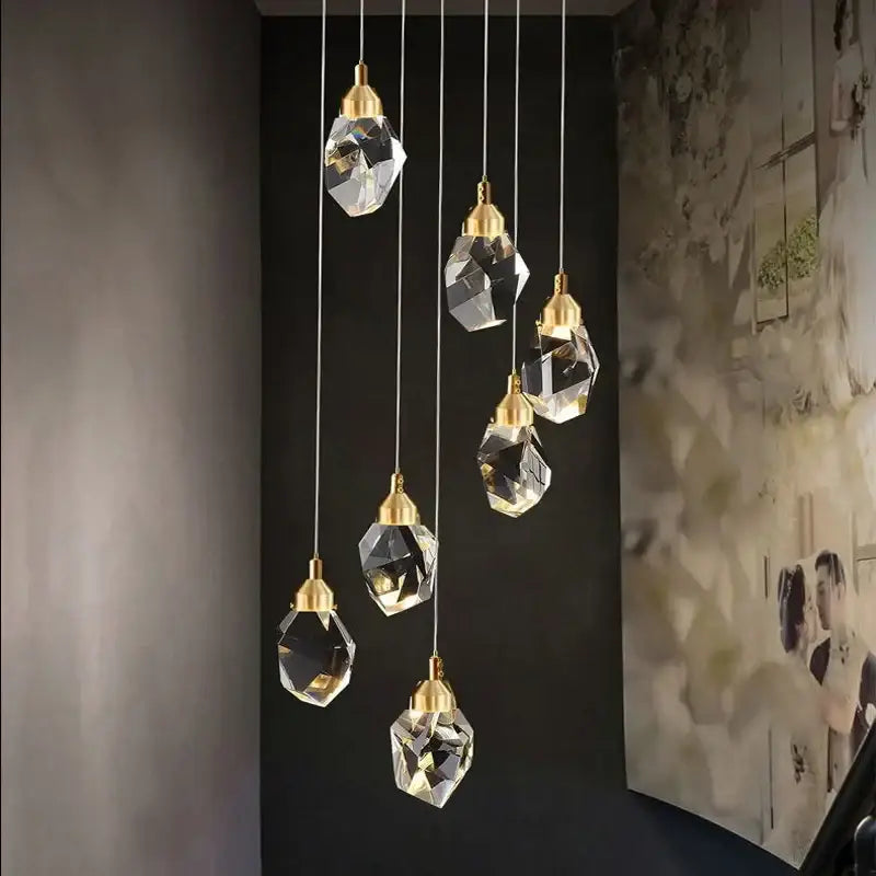 A set of six modern gold diamond crystal chandelier pendant lights with faceted glass shades for living room lighting