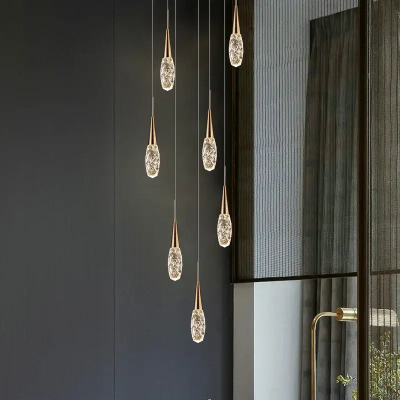 Five gold-toned modern diamond crystal chandelier pendant lights with faceted crystal glass shades for living room use