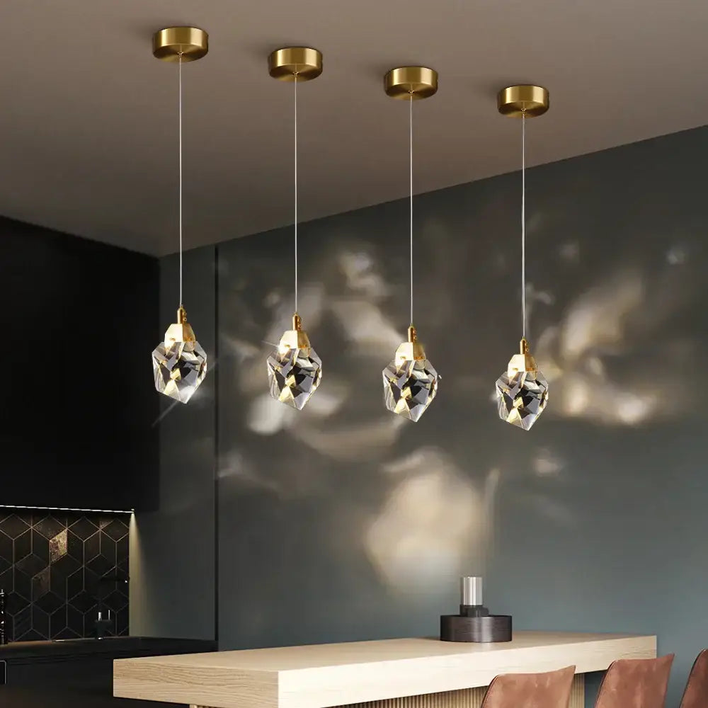 Four elegant modern gold diamond crystal led pendant lights with fixtures hang in a dining room crystal led ceiling chandelier