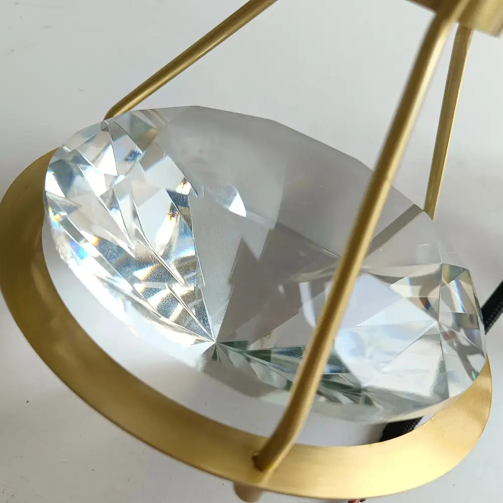 Modern gold diamond crystal pendant light featuring a clear faceted crystal diamond pendant in a gold-toned frame for bedroom illumination pendant lights