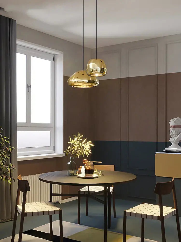 Two sleek gold-finished pendant lamps with glass gold ceiling design for modern dining room decorbites lighting