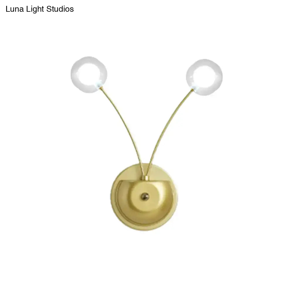 Modern gold double arm wall lamp with clear glass globe bulbs in a gold-toned inch fixture for bedroom use