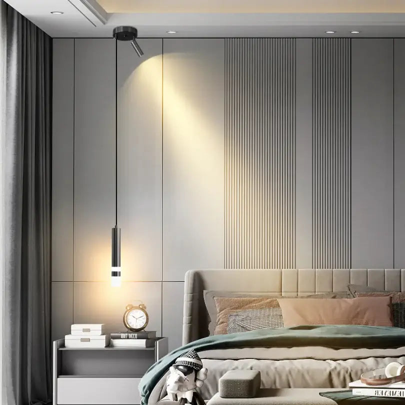 Modern gold double head led pendant lights with sleek black cylindrical shades hanging above bedside table