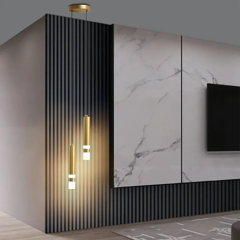 Modern gold double head led pendant lights with cylindrical shades casting warm light against dark paneling for bedroom