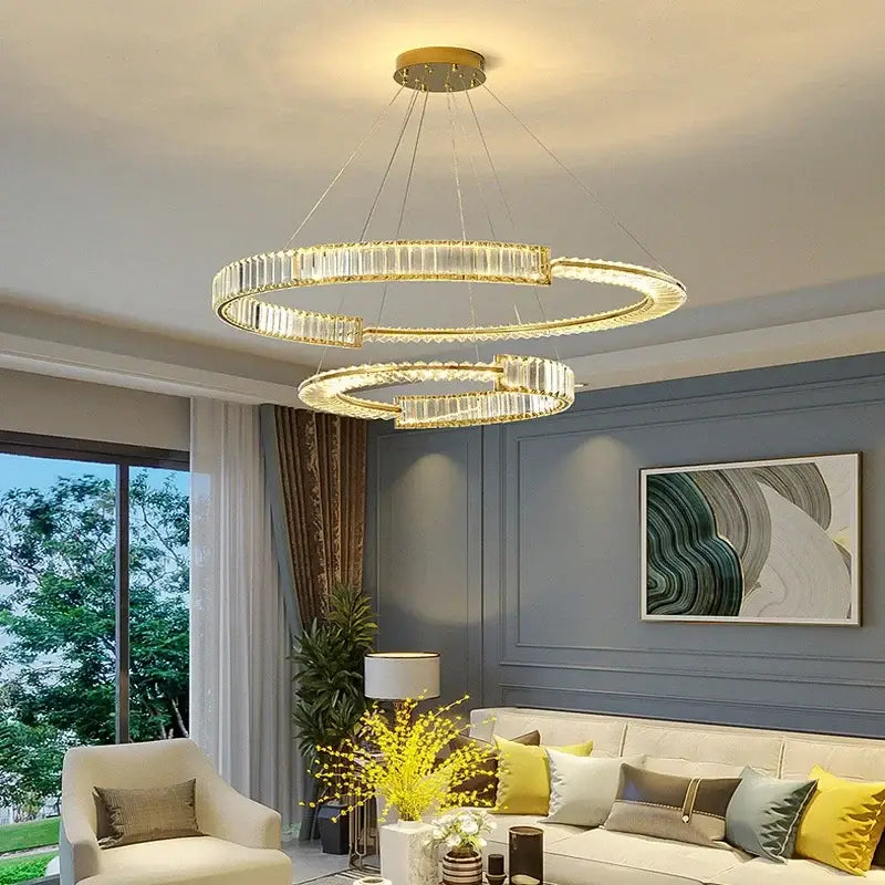 Modern gold double ring decorbites crystal chandeliers with crystal accents hanging in a dining room