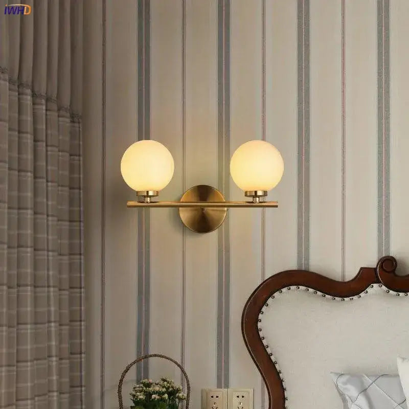 Modern gold led wall lights with brass finish and dual frosted glass ball shades for bedroom use