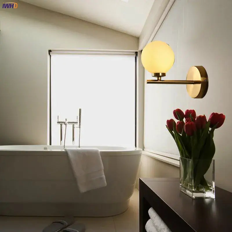 Modern gold dual glass ball led wall lights featuring a gold-toned wall sconce with a glowing amber glass ball shade