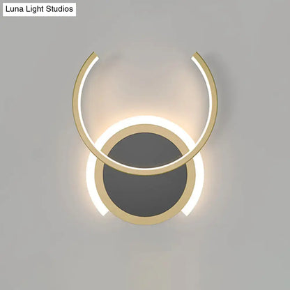 Modern gold dual ring led wall sconce with two concentric circular rings emitting a warm glow for bedroom lighting