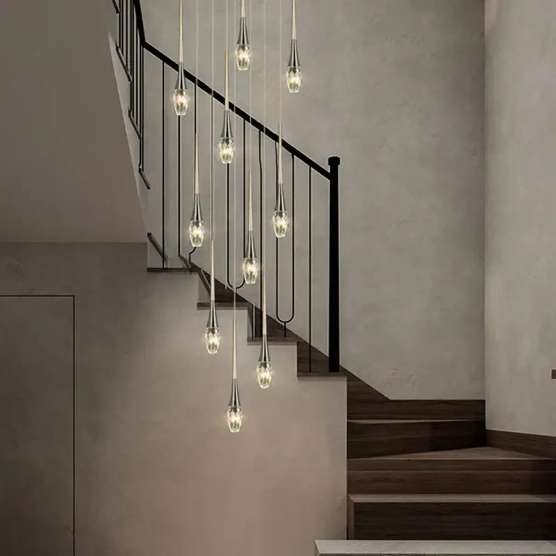A modern gold elegant crystal chandelier with slender teardrop glass pendants by decorbites for living room decor