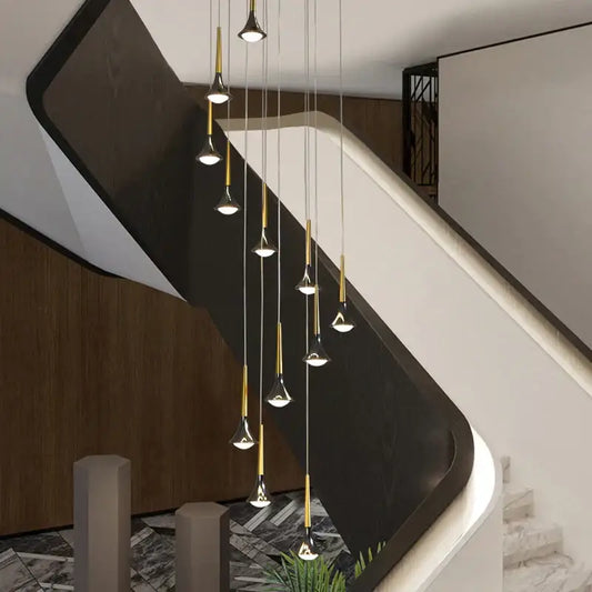 Modern gold elegant horn-shaped chandelier with sleek conical glass shades hanging above staircase decorbites elegant