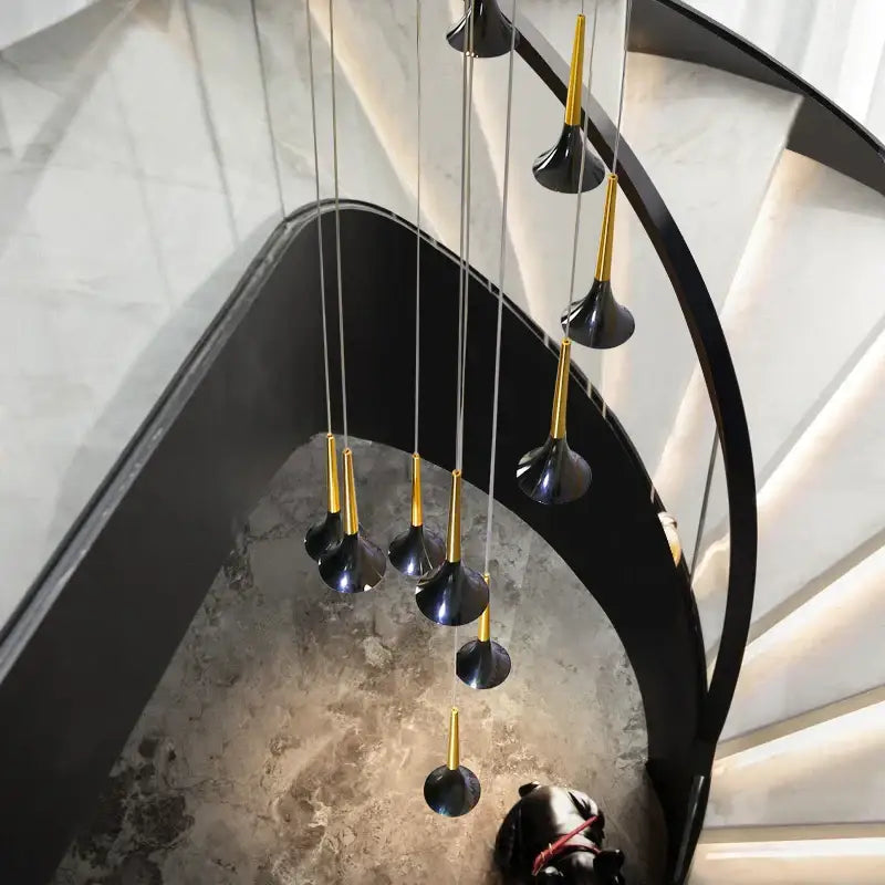 Modern gold elegant horn-shaped chandelier with black and gold pendant lights cascades above staircase decorbites elegant