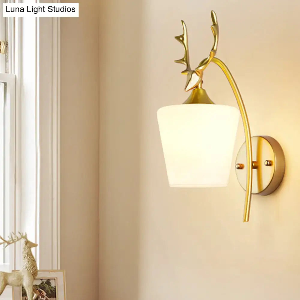Modern gold elk led incandescent wall sconce with a gold-toned deer head and frosted white glass shade for bedroom lighting