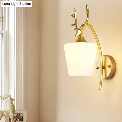 Modern gold elk led incandescent wall sconce with a gold-toned deer head and frosted white glass shade for bedroom lighting