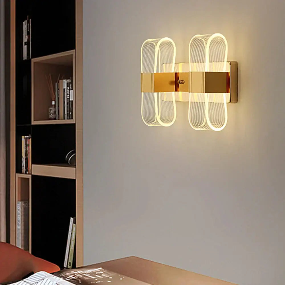 Modern gold accent elliptical led wall lamp with illuminated curved wireframe design for bedroom decorbites decor