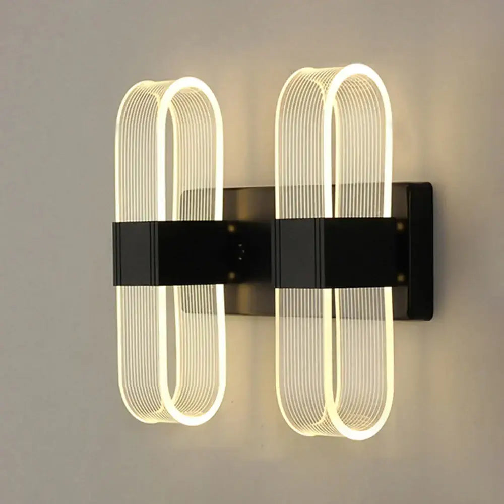 Modern black wall lamp with two illuminated curved led fixtures, perfect for decorbites elliptical led bedroom decor