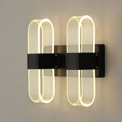 Modern black wall lamp with two illuminated curved led fixtures, perfect for decorbites elliptical led bedroom decor