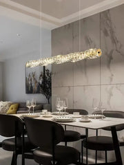 A modern gold elongated glass chandelier led with gold-toned accent hangs above the dining table chandelier led ceiling