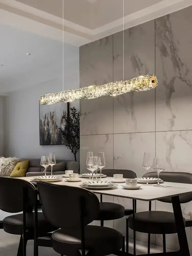 A modern gold elongated glass chandelier led with gold-toned accent hangs above the dining table chandelier led ceiling