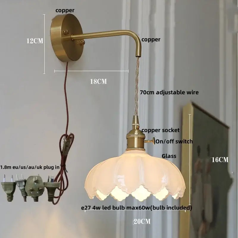 Antique brass wall light with clear petal-shaped glass shade perfect as a modern gold faceted bedroom wall lamp