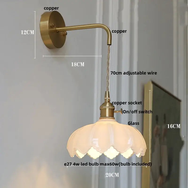 Modern gold faceted clear glass wall lamp featuring a brass-finished wall light with petal-shaped glass shade for bedroom use