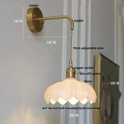 Modern gold faceted clear glass wall lamp featuring a brass-finished wall light with petal-shaped glass shade for bedroom use