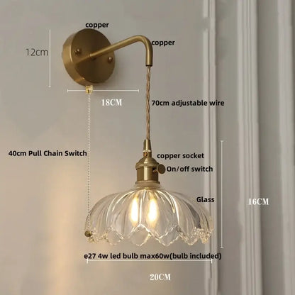 Modern copper-finished wall light with clear petal-shaped glass shade and adjustable wire ideal for bedroom use