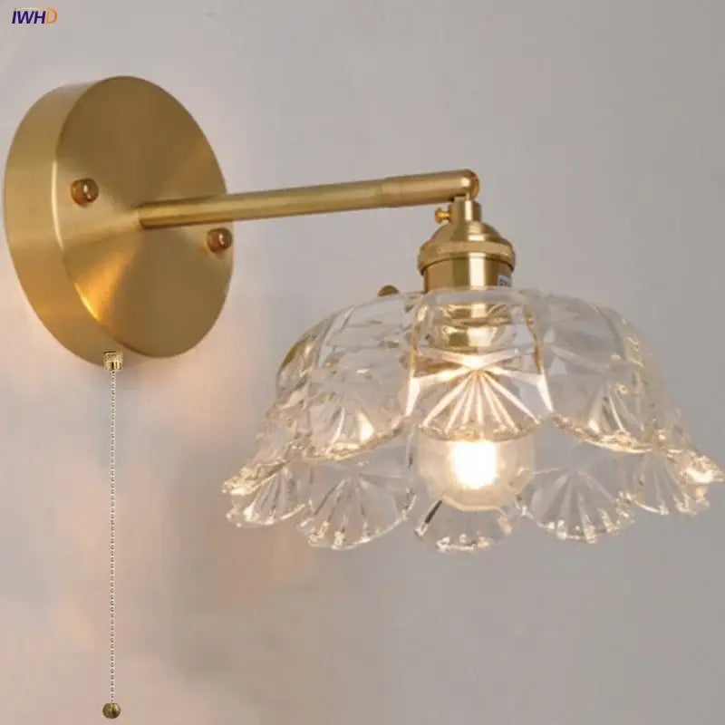 Modern gold faceted clear glass wall lamp with crystal shade designed as a bedroom wall light fixture
