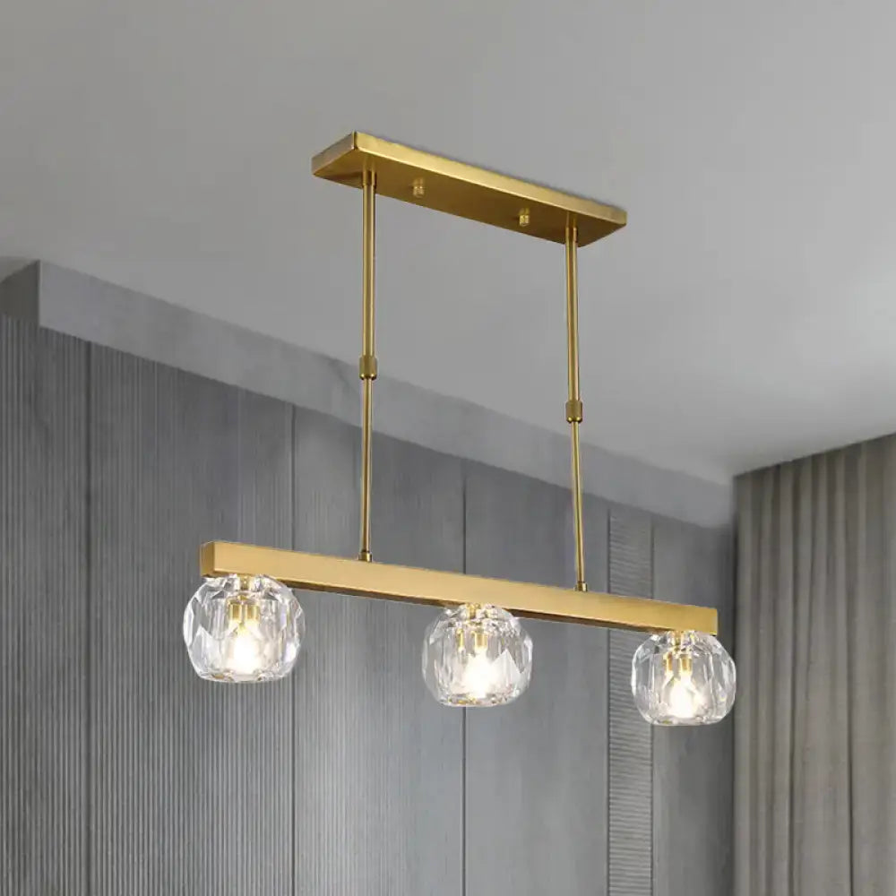 Modern gold island pendant light with three faceted crystal sphere shades for kitchen and dining room use
