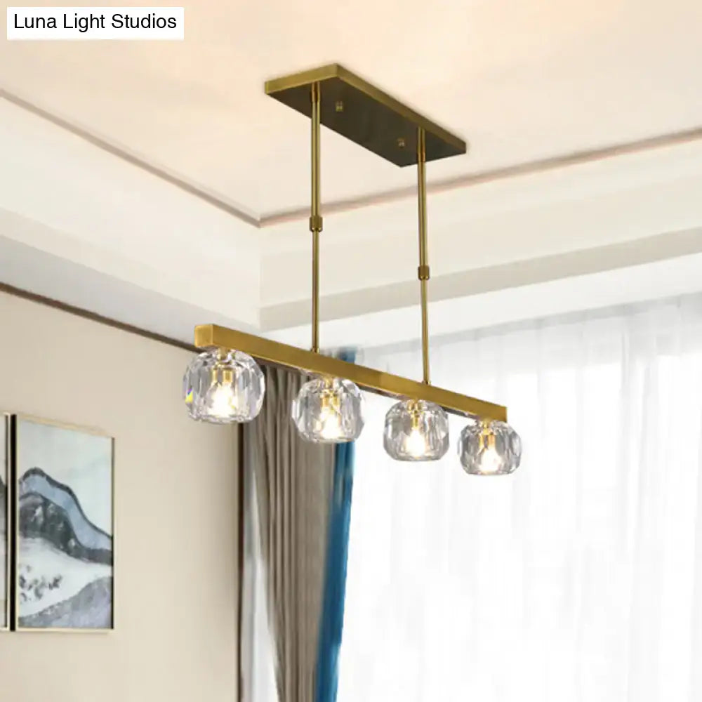 Modern gold island pendant light with brass finish and four faceted crystal sphere shades for kitchen dining room