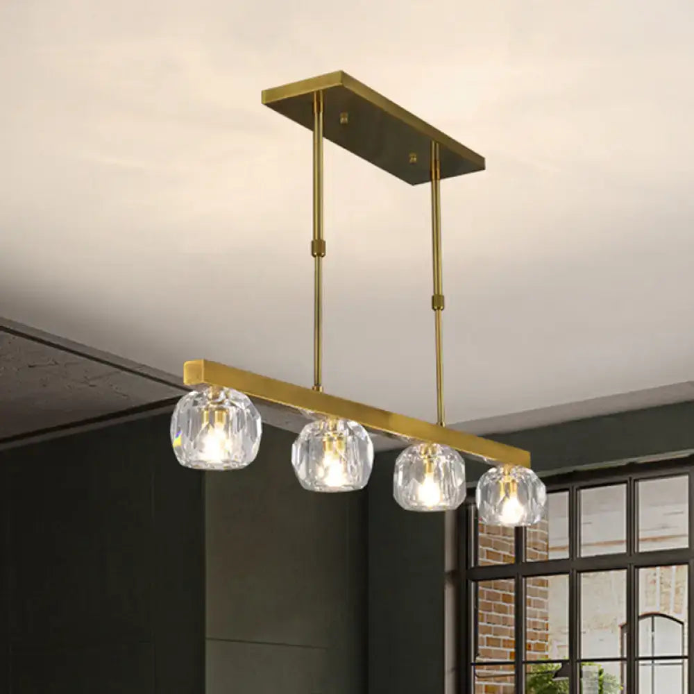Modern gold island pendant light with four faceted crystal sphere shades for kitchen and dining room use