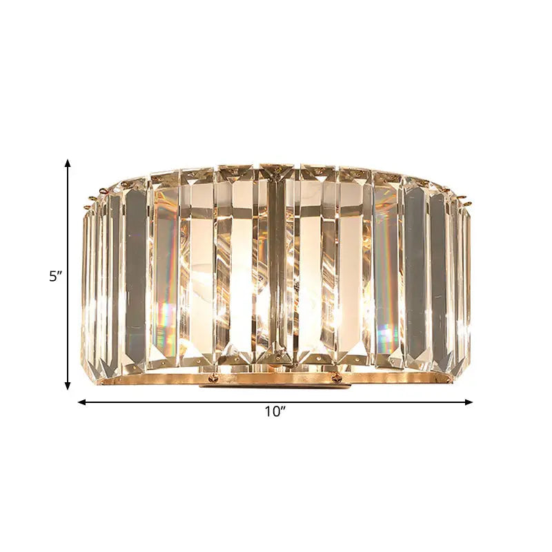 Modern wall sconce with vertical crystal prisms in a gold finish metal frame for bedroom lighting
