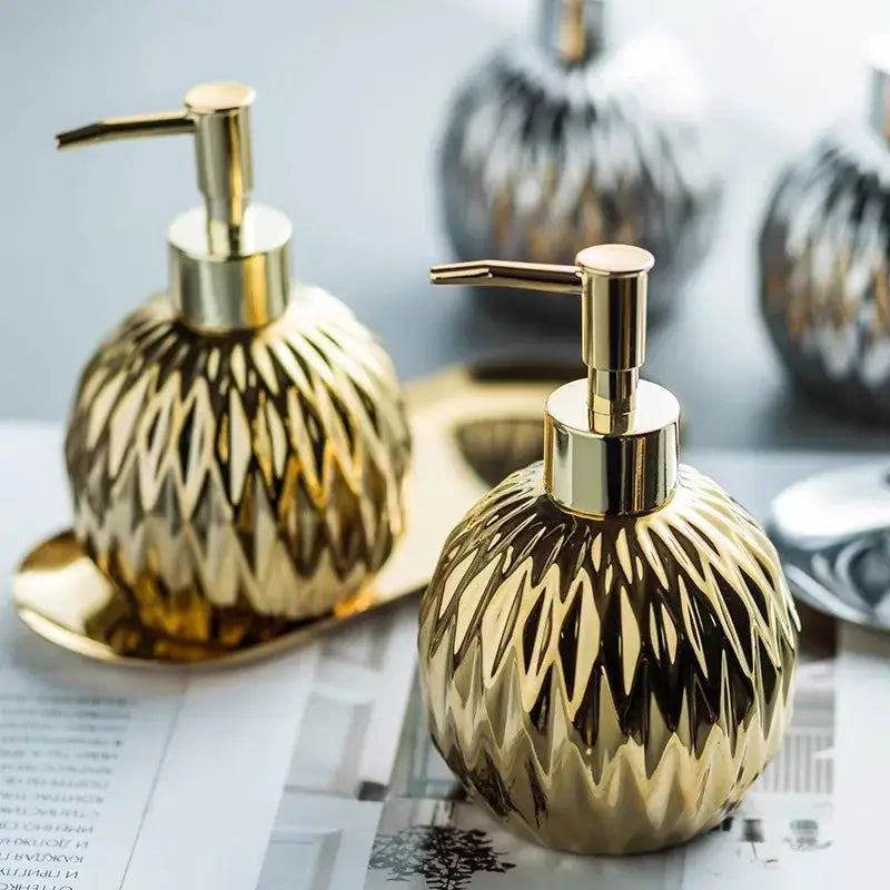 Modern gold faceted glass liquid soap dispenser with sleek metallic pump for elegant bathroom decor and liquid soap use