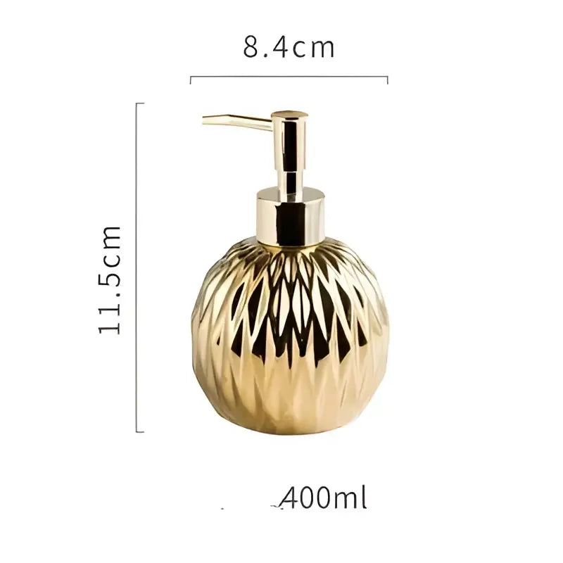 Modern gold faceted glass liquid soap dispenser with a sleek metallic pump for bathroom decor use
