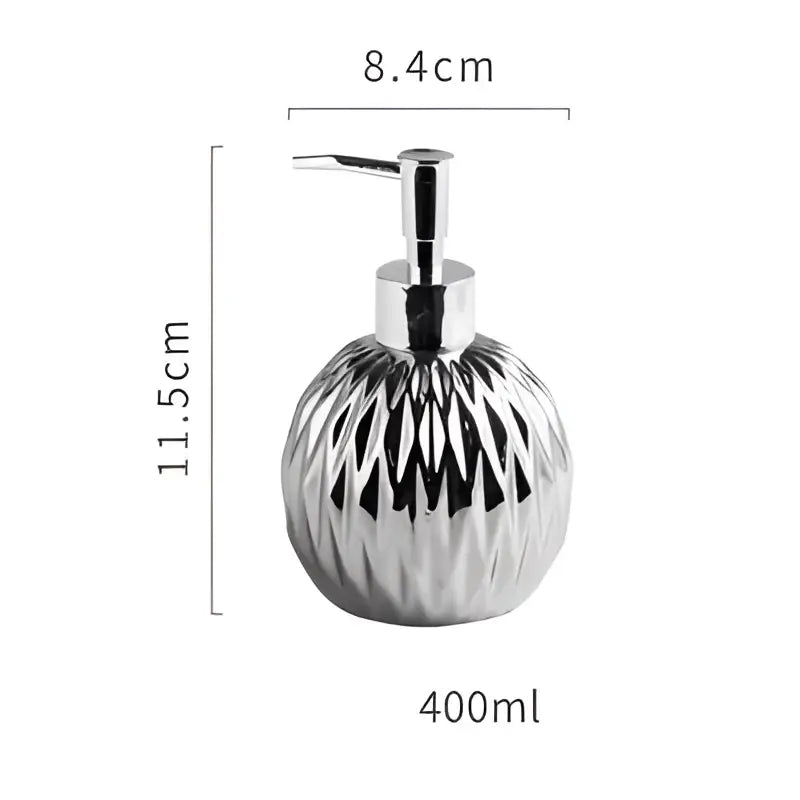 Modern gold faceted glass liquid soap dispenser with chrome finish and sleek pump top for bathroom decor