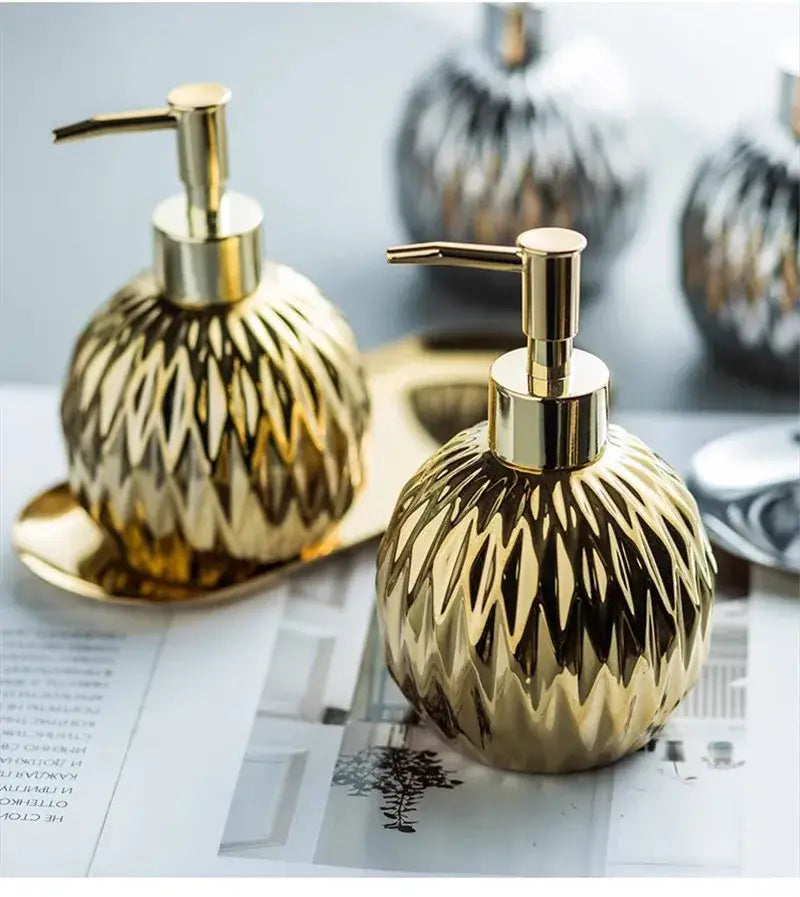 Modern gold faceted glass liquid soap dispenser set with metallic pump tops for elegant bathroom decor