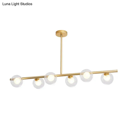 Modern gold finish linear pendant light with five clear glass globes and sleek horizontal bar design for kitchen use