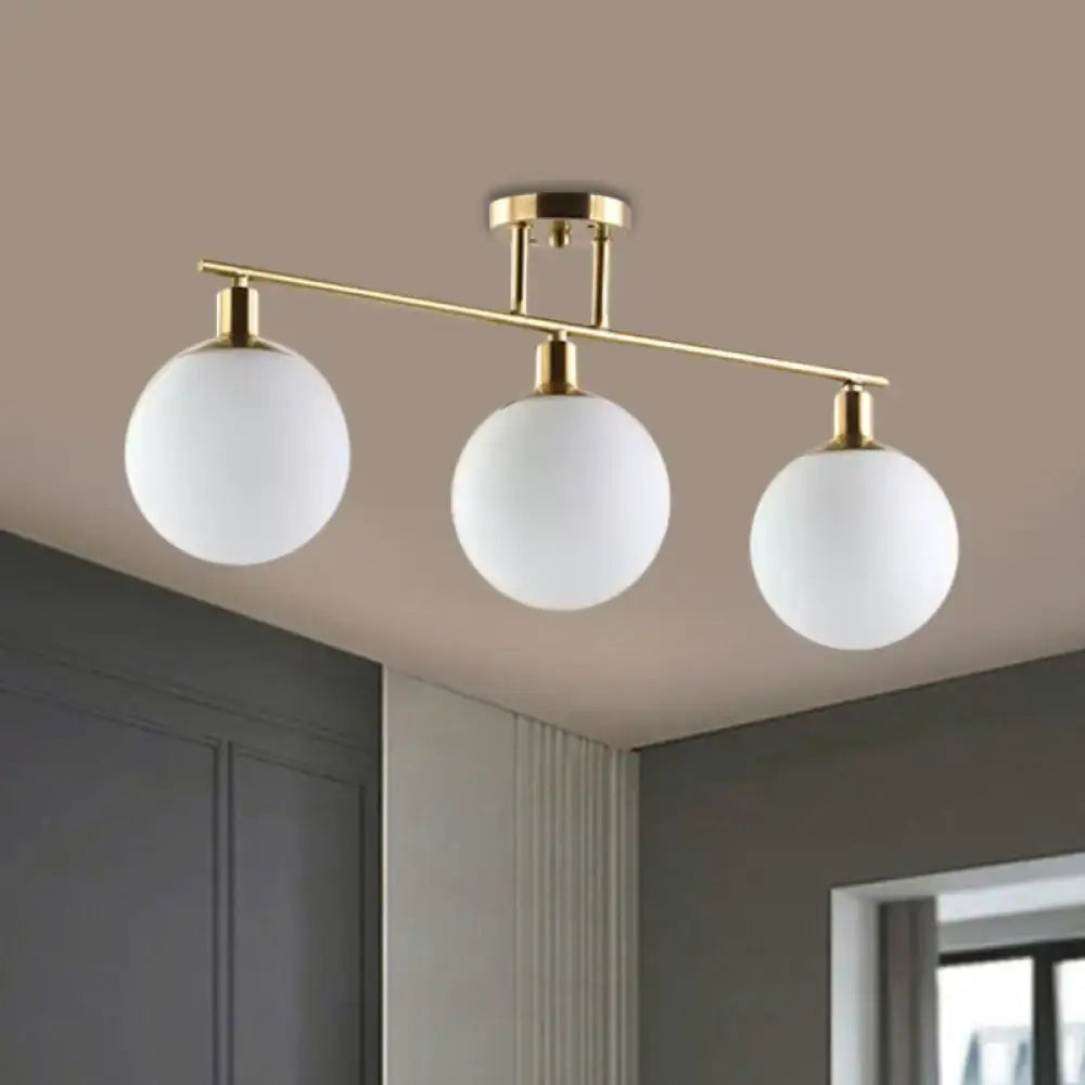 Gold finish DecorBites™ linear chandelier pendant light with three milk glass frosted white spherical shades