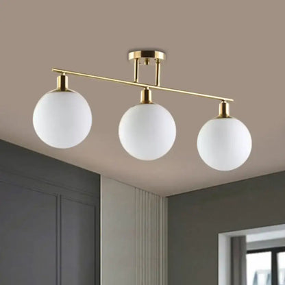 Gold finish DecorBites™ linear chandelier pendant light with three milk glass frosted white spherical shades