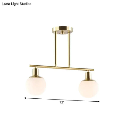 Modern brass linear chandelier pendant light with two frosted milk glass globe shades and gold finish