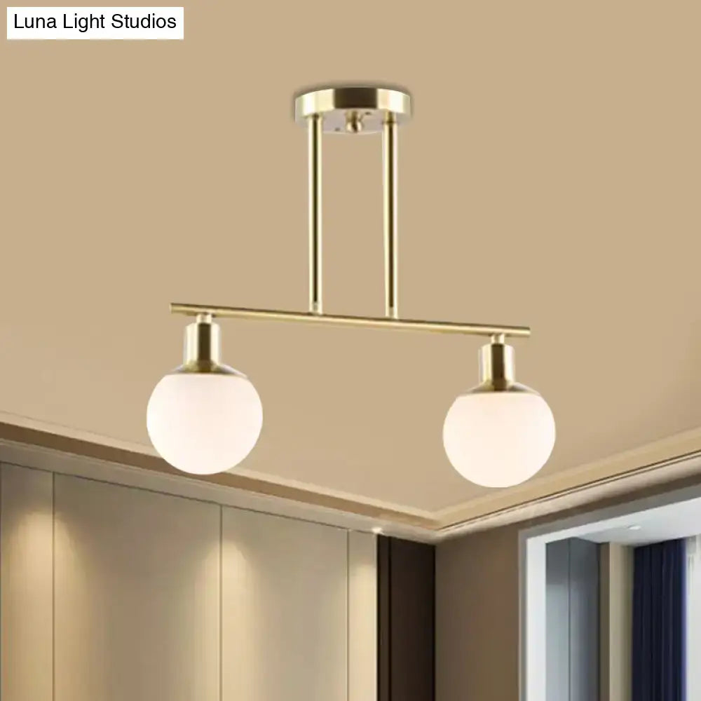 DecorBites™ modern linear chandelier with gold finish and two milk glass spherical frosted globe shades